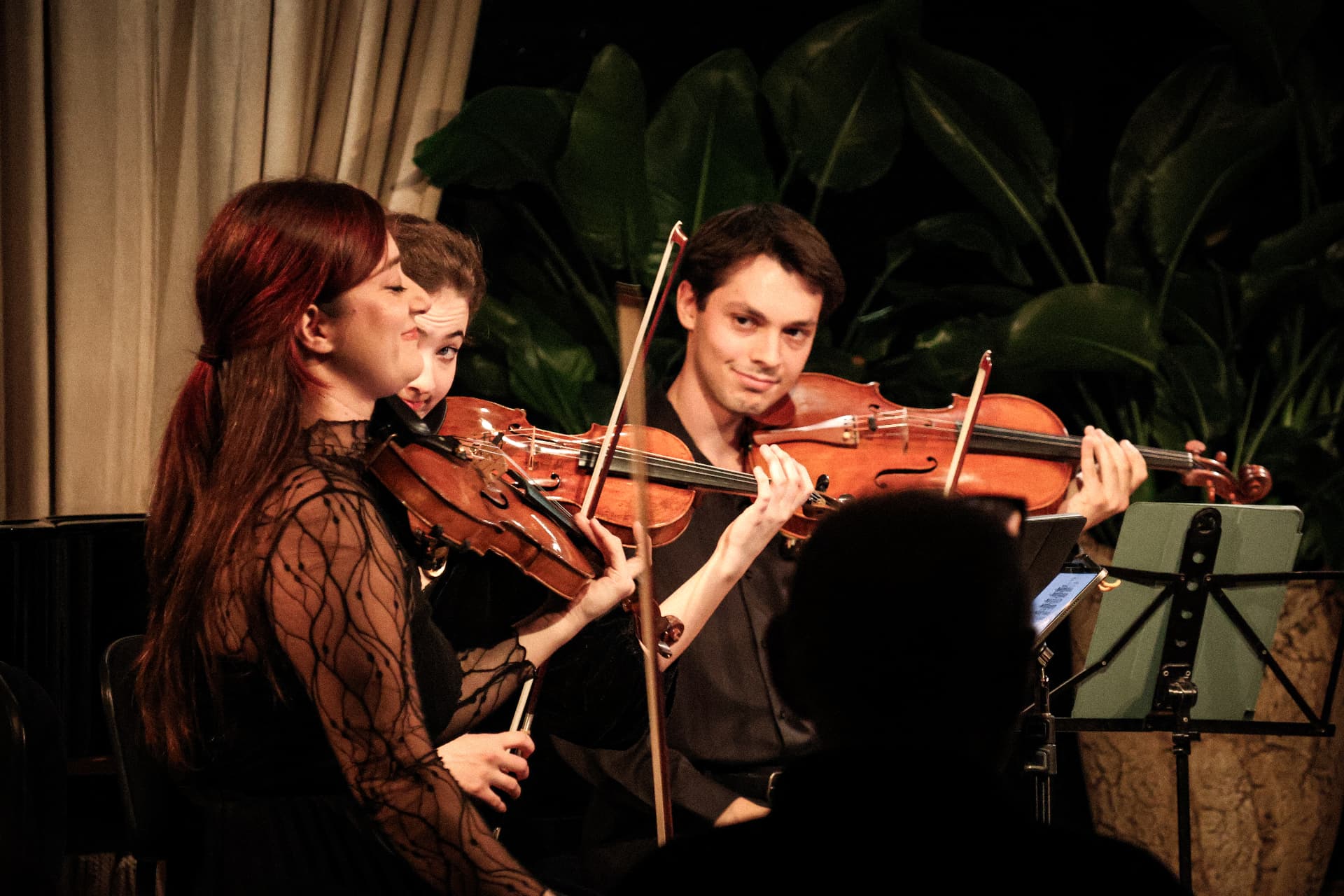 Violinists smiling together during a performance
