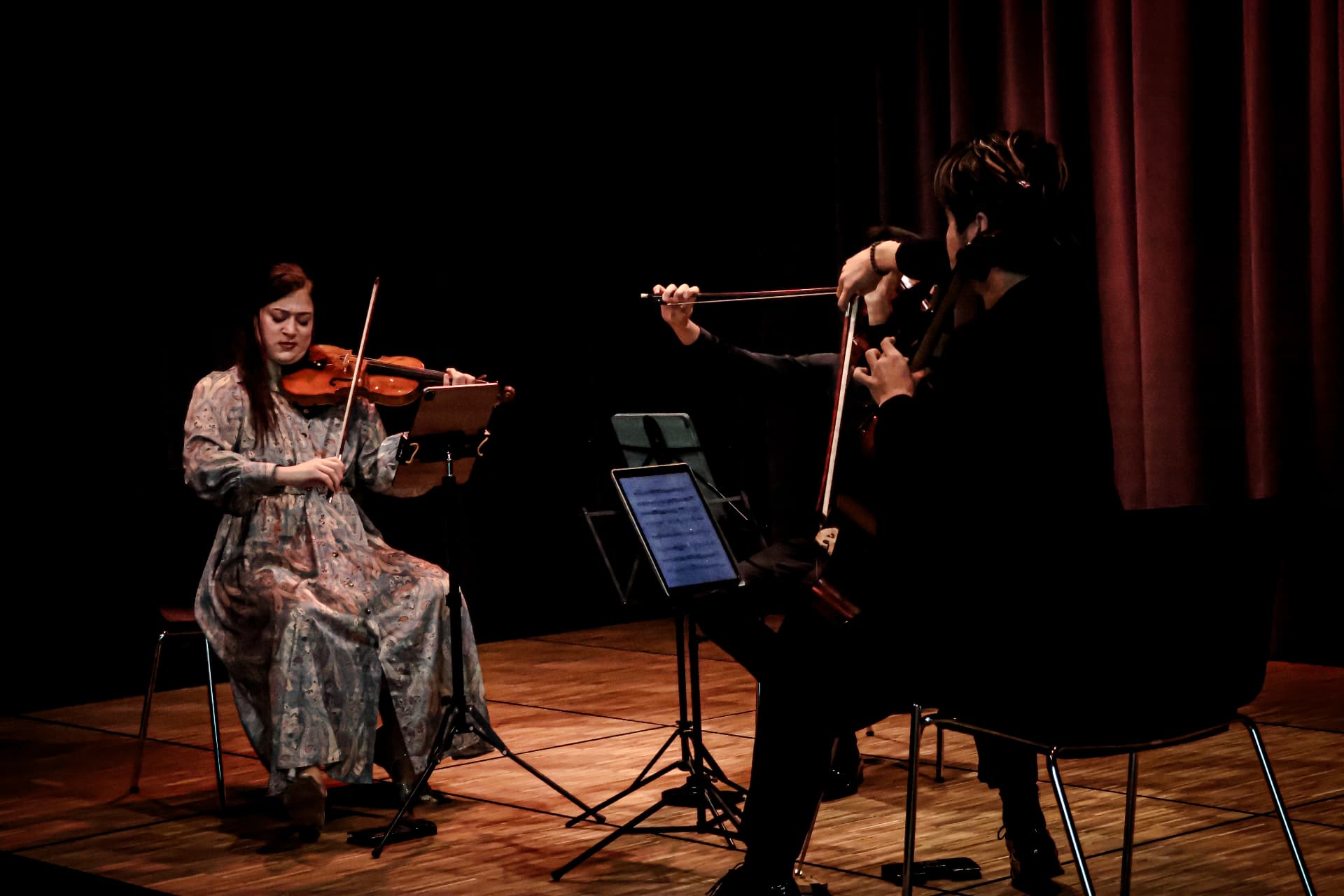 Violinist performing with a cellist on stage