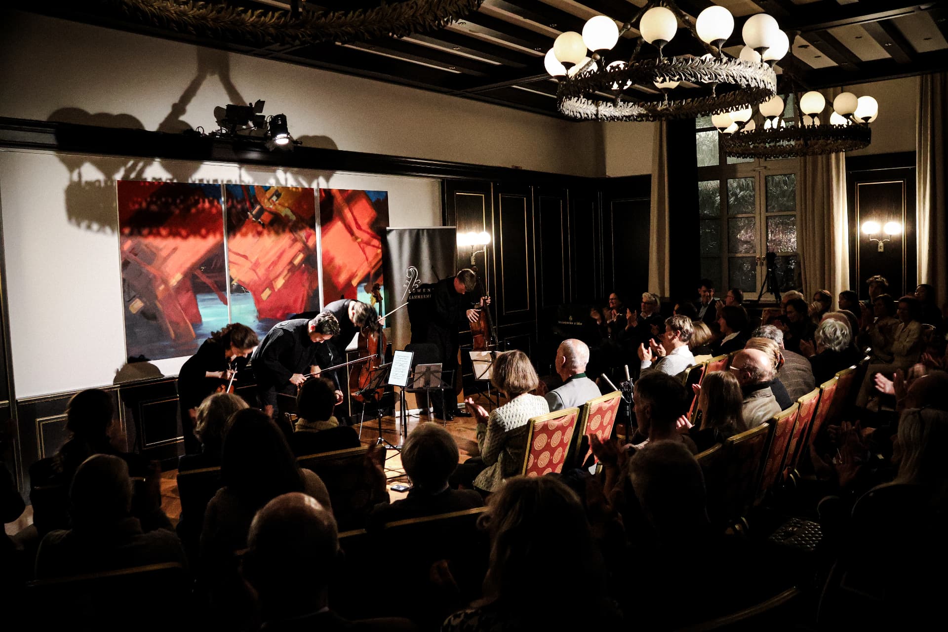 Musicians bowing to an applauding audience