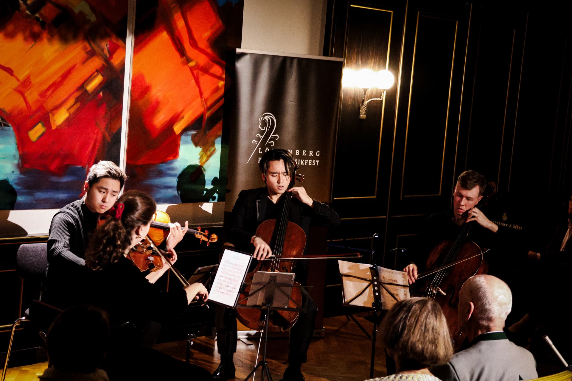 Trio performing close-up beside the festival banner