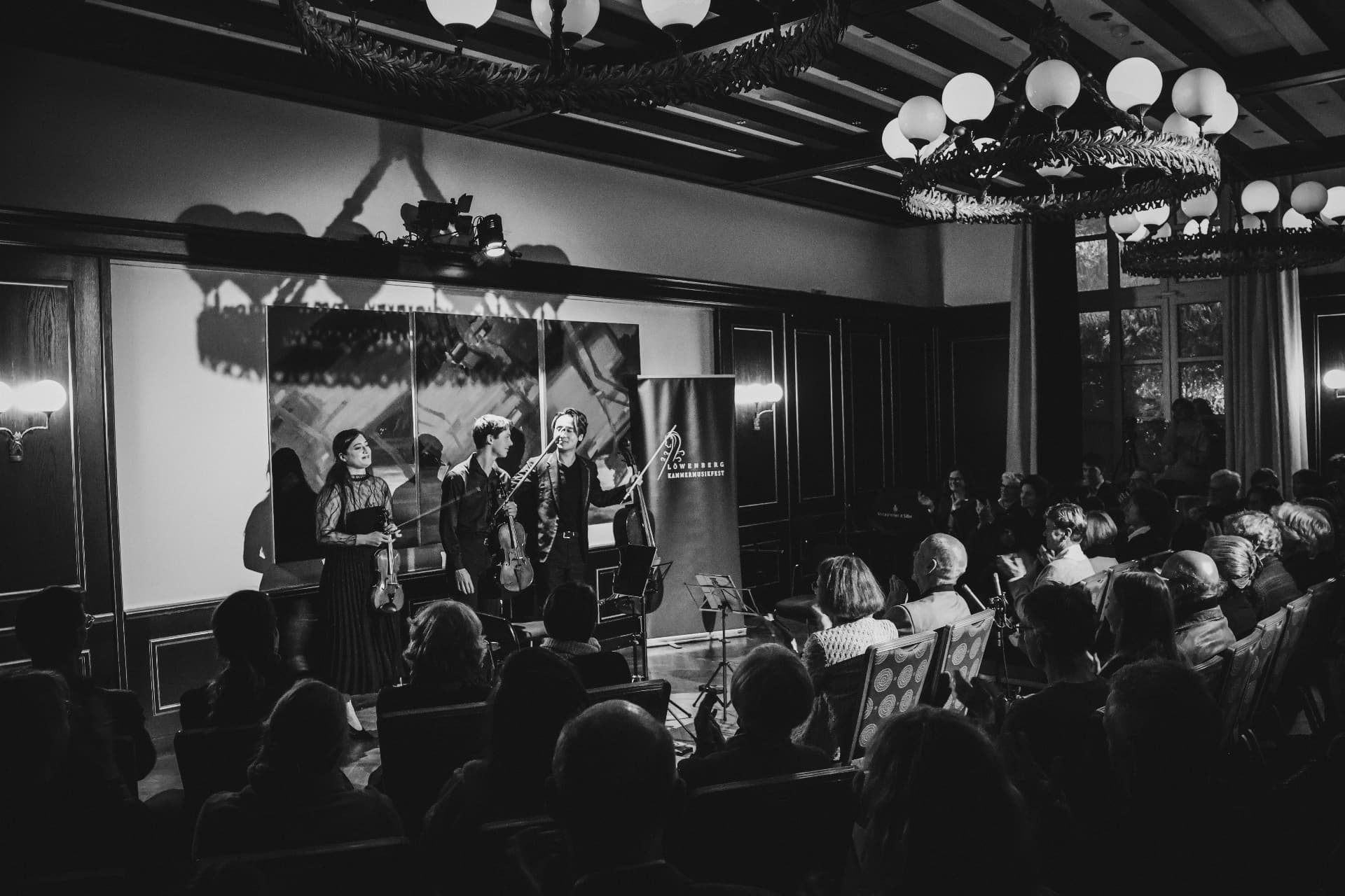 Musicians taking a bow before the audience in black and white